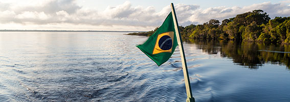 View of the backside of a traditional boat with flag of Brazil in the negro river